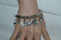 Bracelet pampilles et perles métal ciselé et argenté et strass de verre sur cordon élastique noir